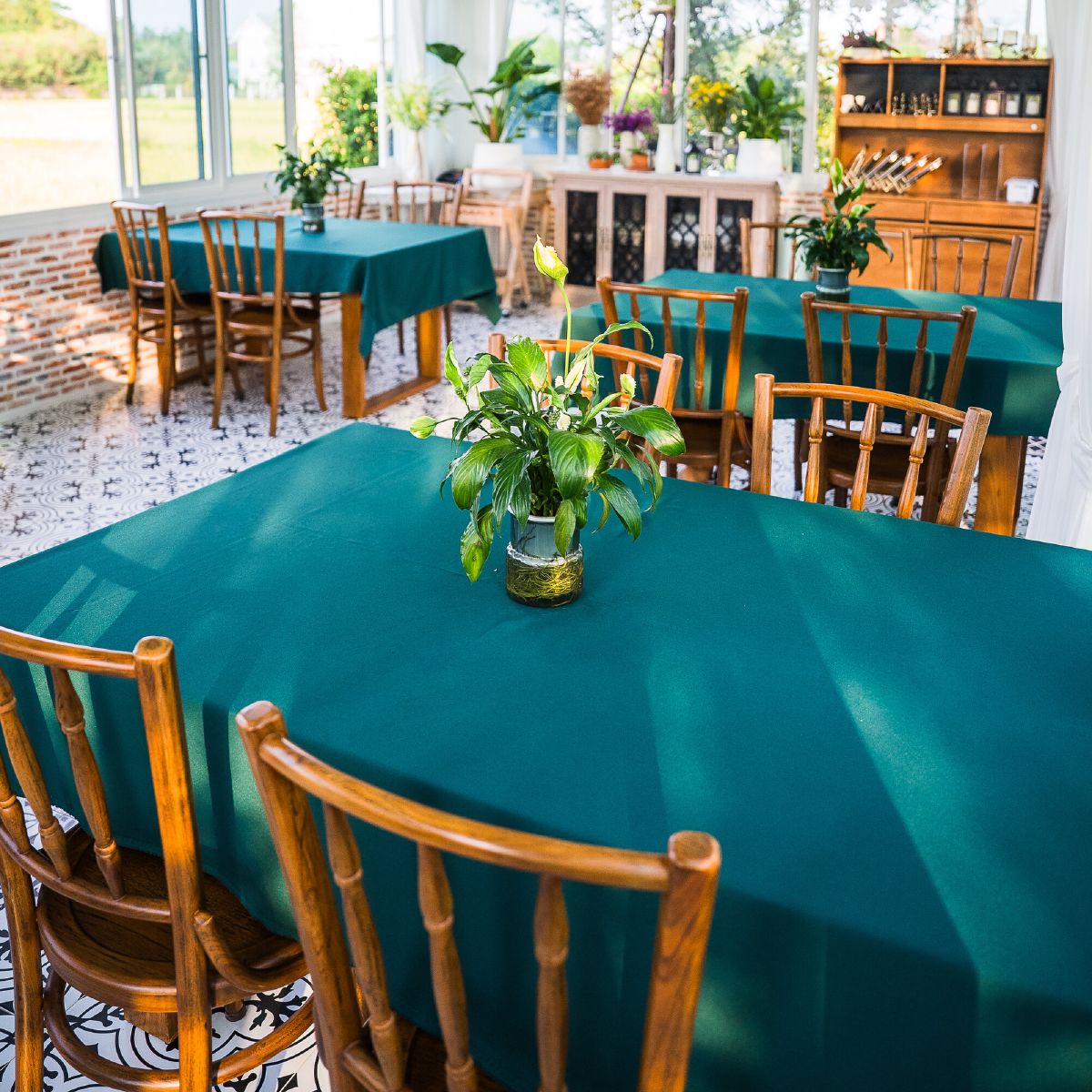 The WIROON dining room, several tables laid in teal linen beneath large windows